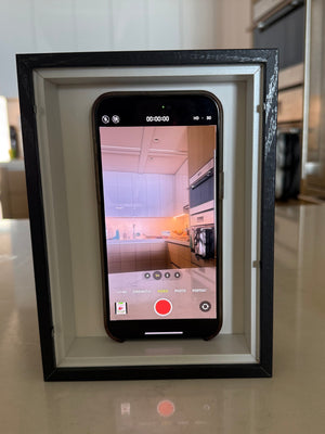 Smartphone as a hidden camera to capture pranks in What The Frame, with a video camera and microphone setup.